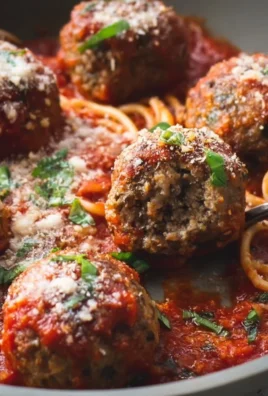 Baked Italian meatballs served in marinara sauce with fresh herbs