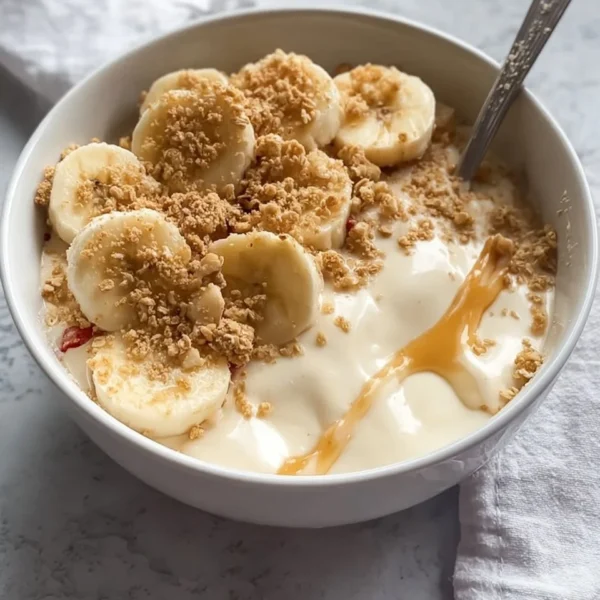 Delicious Banana Pudding Greek Yogurt Bowl topped with fresh bananas and a drizzle of honey