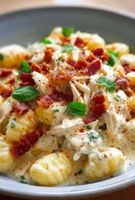 Creamy Crack Chicken Gnocchi in a bowl topped with herbs
