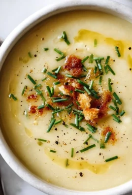 Bowl of creamy potato leek soup garnished with fresh herbs
