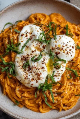 Creamy red pepper pasta topped with fresh burrata and herbs