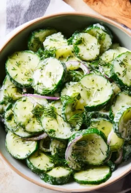 Bowl of fresh Cucumber Dill Salad garnished with herbs and spices.