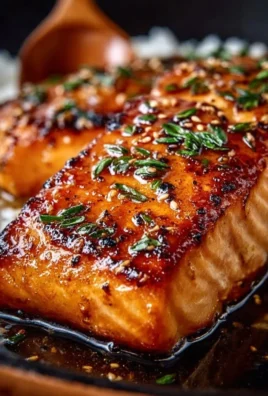 Crispy honey garlic glazed salmon garnished with herbs on a white plate