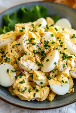 Delicious easy egg salad in a bowl with fresh herbs and spices.