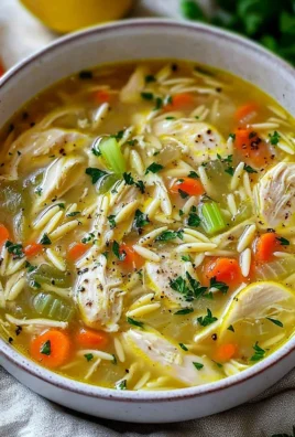 Bowl of Greek Lemon Chicken Soup garnished with fresh herbs and lemon slices