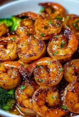 Plate of high-protein honey garlic shrimp garnished with herbs