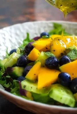 Mango cucumber salad with blueberries and avocado served in a bowl