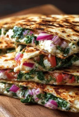Mediterranean Quesadillas with spinach, feta cheese, mozzarella, and red onion on a plate