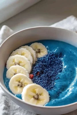 Blue smoothie bowl topped with fresh fruits and nuts