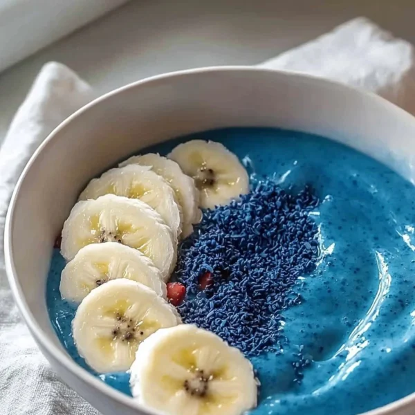 Blue smoothie bowl topped with fresh fruits and nuts