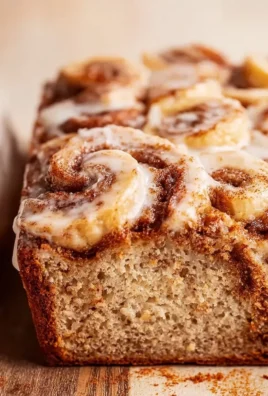 Slice of cinnamon swirled banana bread on a wooden cutting board