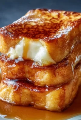 Delicious Hawaiian Roll French Toast served with syrup and fresh fruit