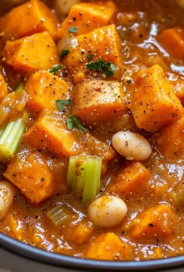 Bowl of hearty vegan sweet potato stew with vegetables and herbs.