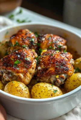 Delicious lemon garlic parmesan chicken thighs served with fresh herbs.