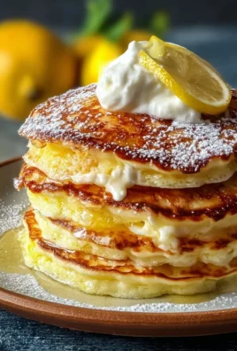 Delicious lemon ricotta pancakes served with a drizzle of syrup and fresh berries