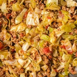 Cabbage and ground beef dish served on a plate with herbs and spices.