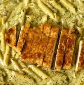 Creamy pesto sauce pasta in a bowl, garnished with fresh basil and parmesan.
