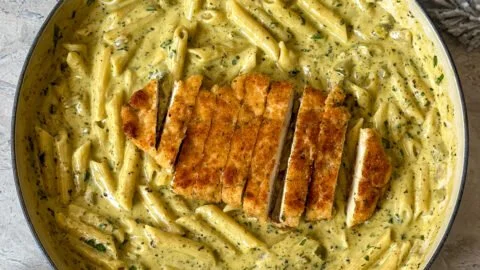 Creamy pesto sauce pasta in a bowl, garnished with fresh basil and parmesan.