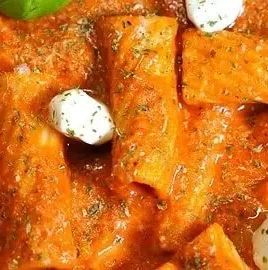 Creamy rigatoni pasta topped with delicious tomato sauce