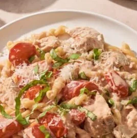 Creamy tomato basil chicken dish served with fresh basil and tomatoes