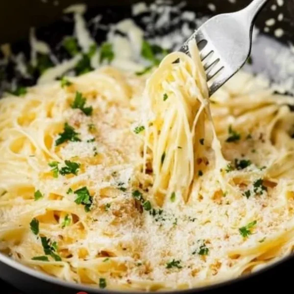 Delicious bowl of Garlic Parmesan Pasta topped with fresh herbs and cheese