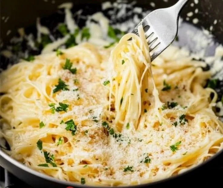 Delicious bowl of Garlic Parmesan Pasta topped with fresh herbs and cheese
