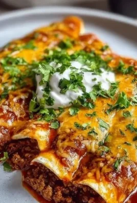 Plate of ground beef enchiladas topped with cheese and sauce