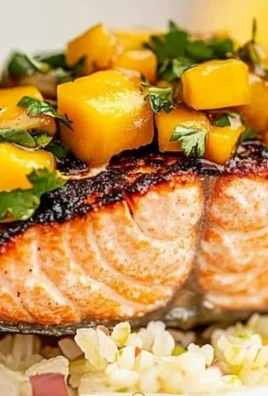 Plate of healthy salmon topped with fresh mango salsa