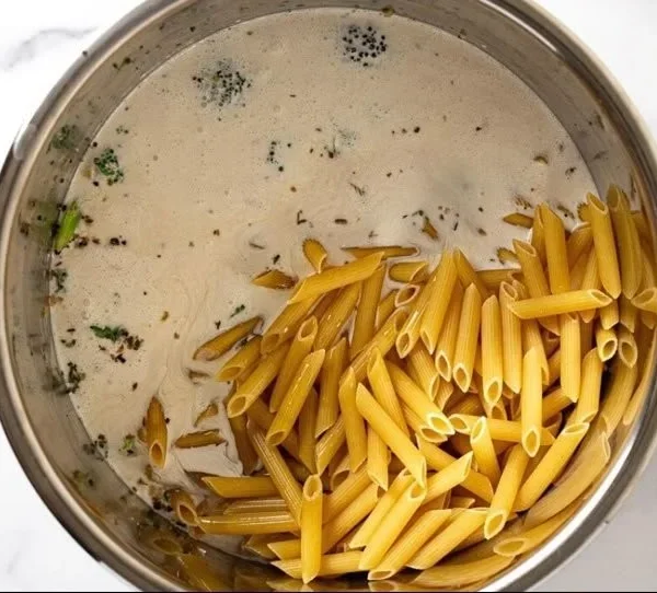 Bowl of creamy garlic pasta made in an Instant Pot, garnished with parsley.