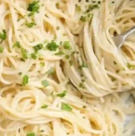 A bowl of One-Pot Garlic Parmesan Pasta garnished with parsley and cheese.