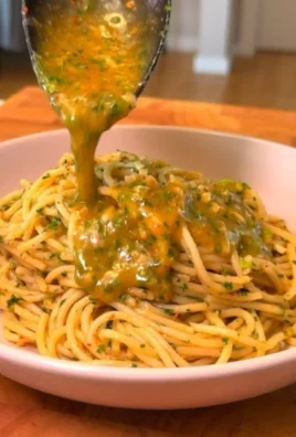 Plate of spaghetti with garlic and oil, garnished with parsley and chili flakes