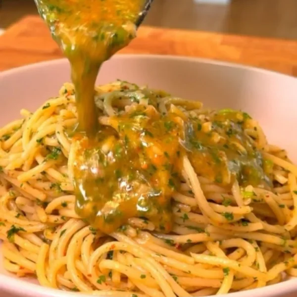 Plate of spaghetti with garlic and oil, garnished with parsley and chili flakes