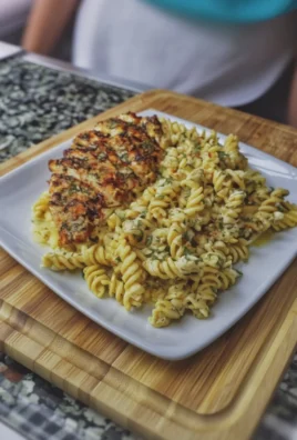 Creamy garlic parmesan chicken pasta dish served on a plate with herbs