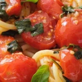 A delicious plate of Tomato Basil Pasta topped with fresh basil leaves