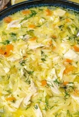 Bowl of Avgolemono, traditional Greek lemon chicken soup garnished with herbs.