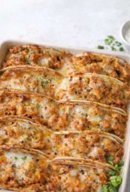 Baked chicken bacon ranch tacos served on a plate with fresh toppings.