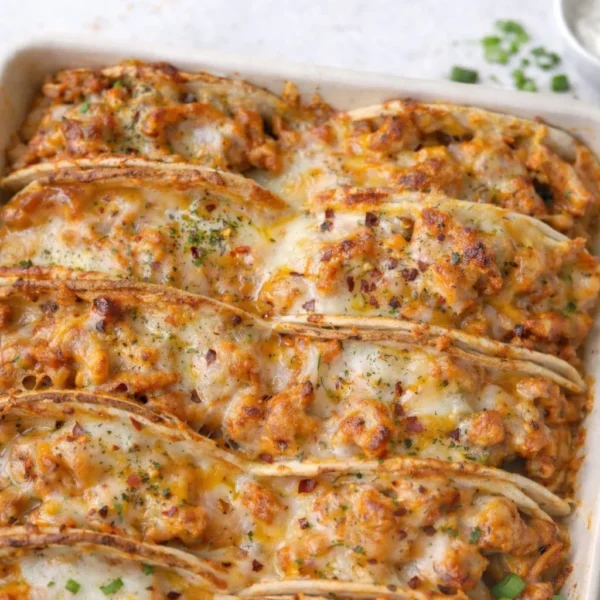 Baked chicken bacon ranch tacos served on a plate with fresh toppings.