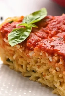 Delicious Baked Spaghetti Pie served with cheese and herbs