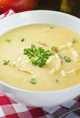 Bowl of creamy lemon rice soup garnished with fresh herbs