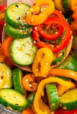 Cucumber and sweet pepper salad garnished with herbs in a bowl