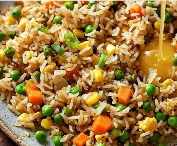 Bowl of easy fried rice with vegetables and eggs, garnished with green onions