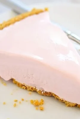 Frozen Pink Lemonade Pie topped with whipped cream and lemon slices