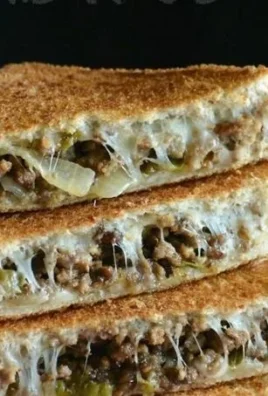 Grilled Cheese Philly Cheesesteak Sandwich topped with melted cheese and steak