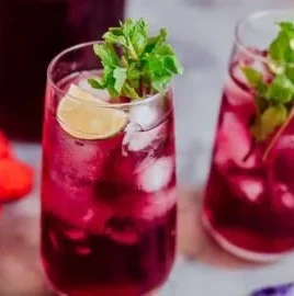 A cup of Hibiscus Tea highlighting its vibrant red color and fresh hibiscus flowers.