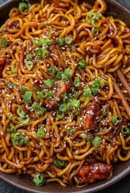 Bowl of Korean spicy chicken noodles garnished with vegetables and chili flakes
