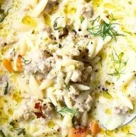 Bowl of homemade Lemon Chicken Orzo Soup with fresh herbs and lemon slices