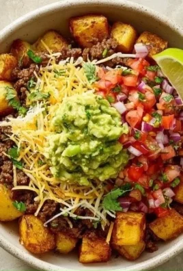 Delicious loaded potato taco bowl with toppings and garnishes.