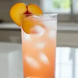 Refreshing Pink Peach Paradise Mocktail served in a tropical setting