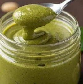 Delicious homemade pistachio cream in a jar with a spoon