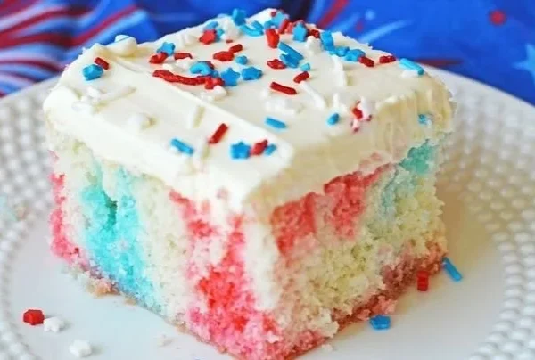 Red White and Blue Poke Cake topped with strawberries and blueberries